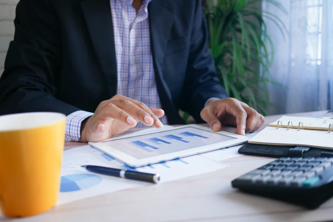 Small business owner reviewing contractor invoices and payment records at a desk