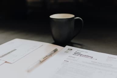 Small business owner reviewing tax forms and contractor payment records at a desk