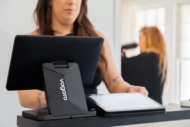 Small business owner counting cash payments at a desk with contractor invoices and tax documents