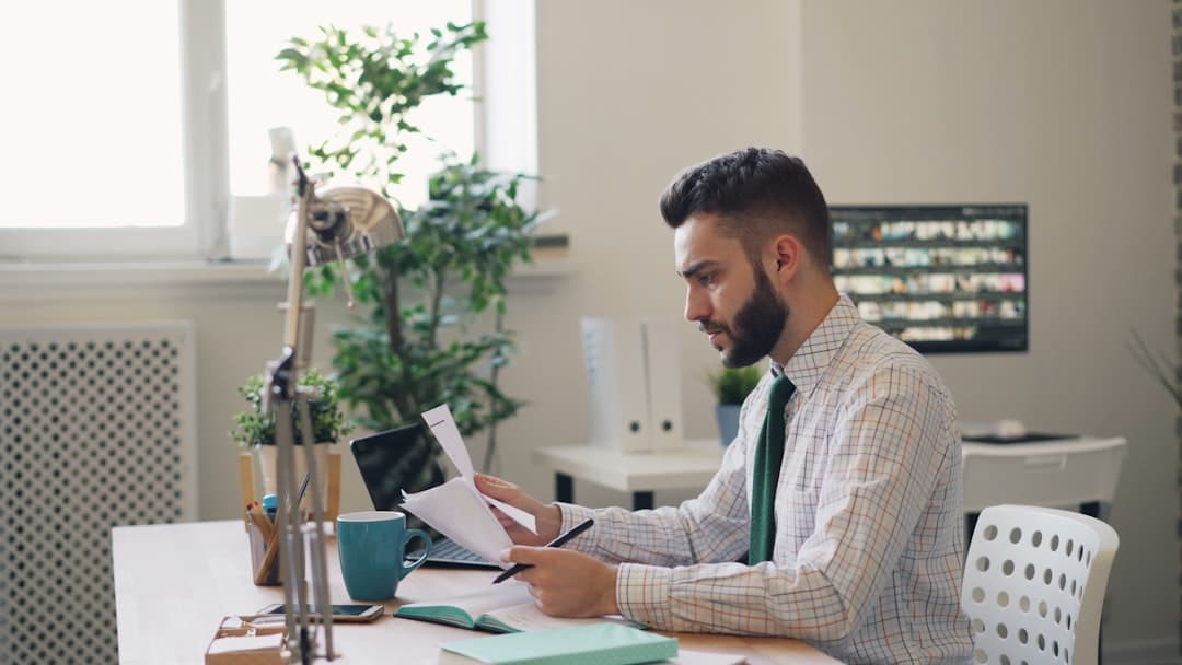 Small business owner reviewing contractor tax documents at a desk