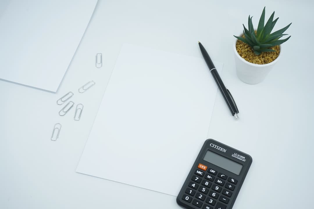 Small business owner reviewing financial documents and calculator on desk