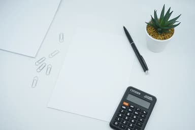 Small business owner reviewing financial documents and calculator on desk