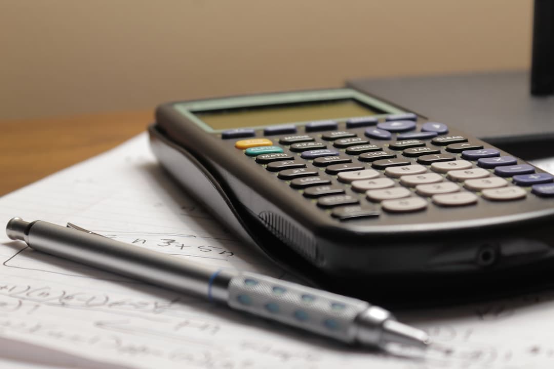 Business professional reviewing worker classification documents at desk with calculator and tax forms