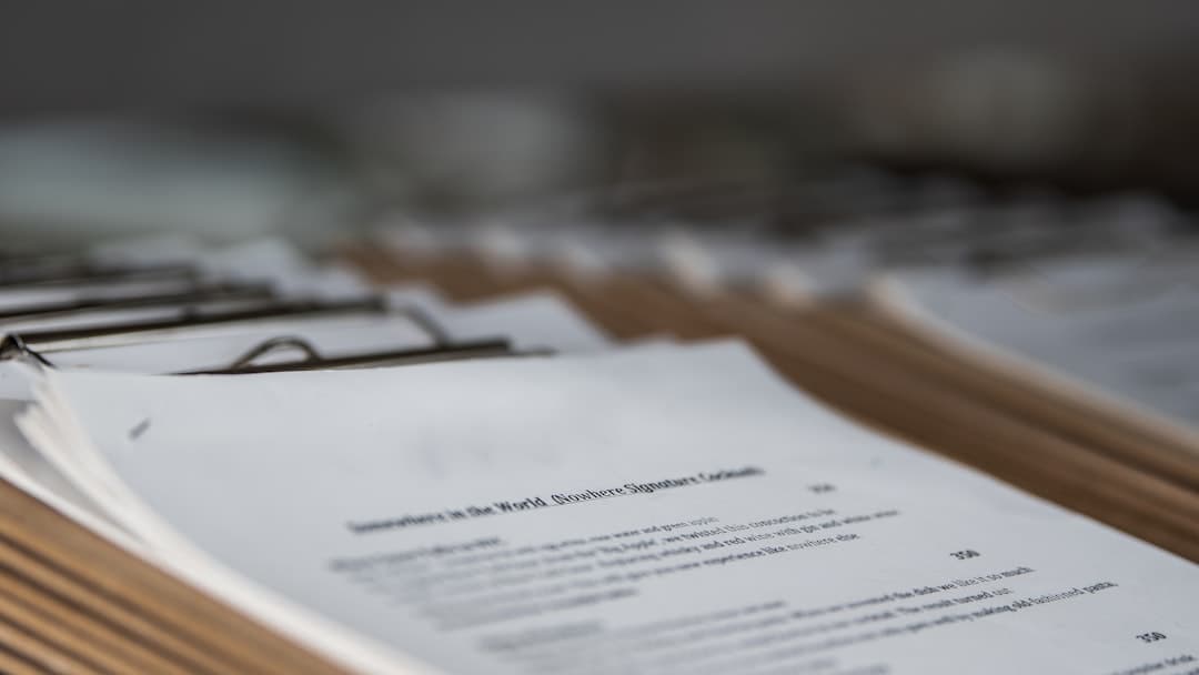 Business professional reviewing contractor documents and updating records at desk