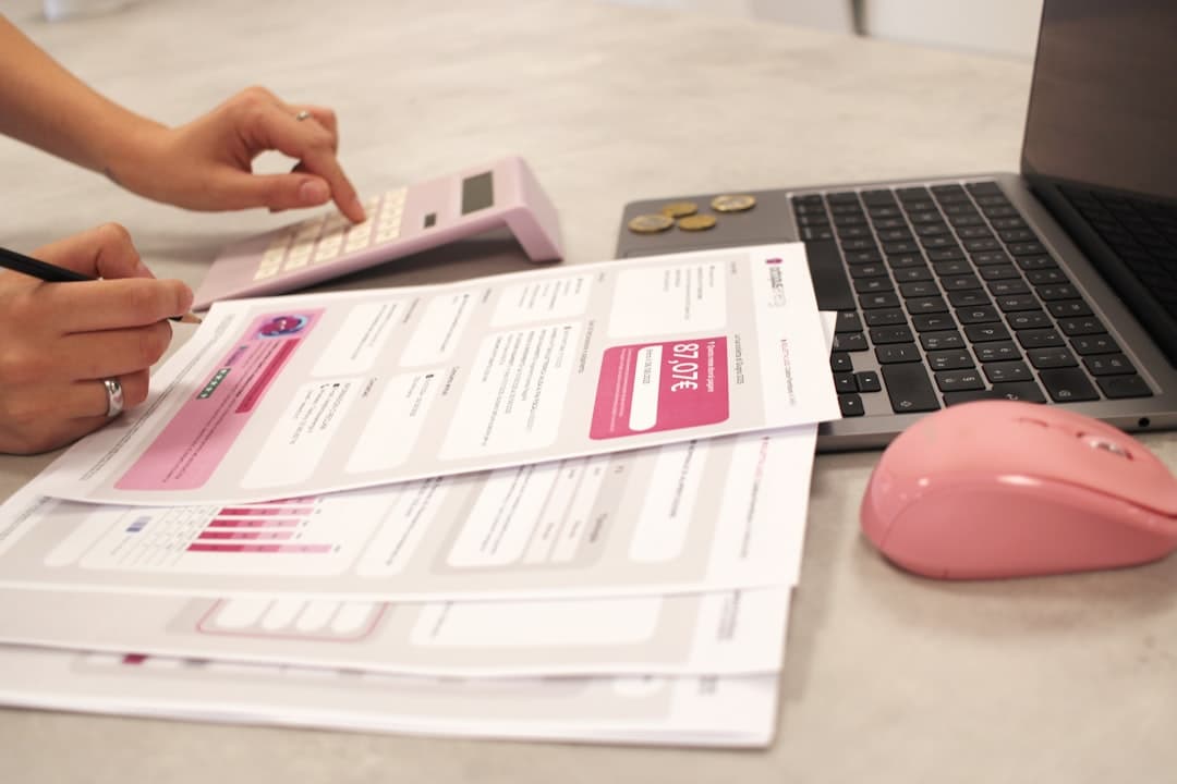 Small business owner reviewing tax documents and forms at desk with calculator