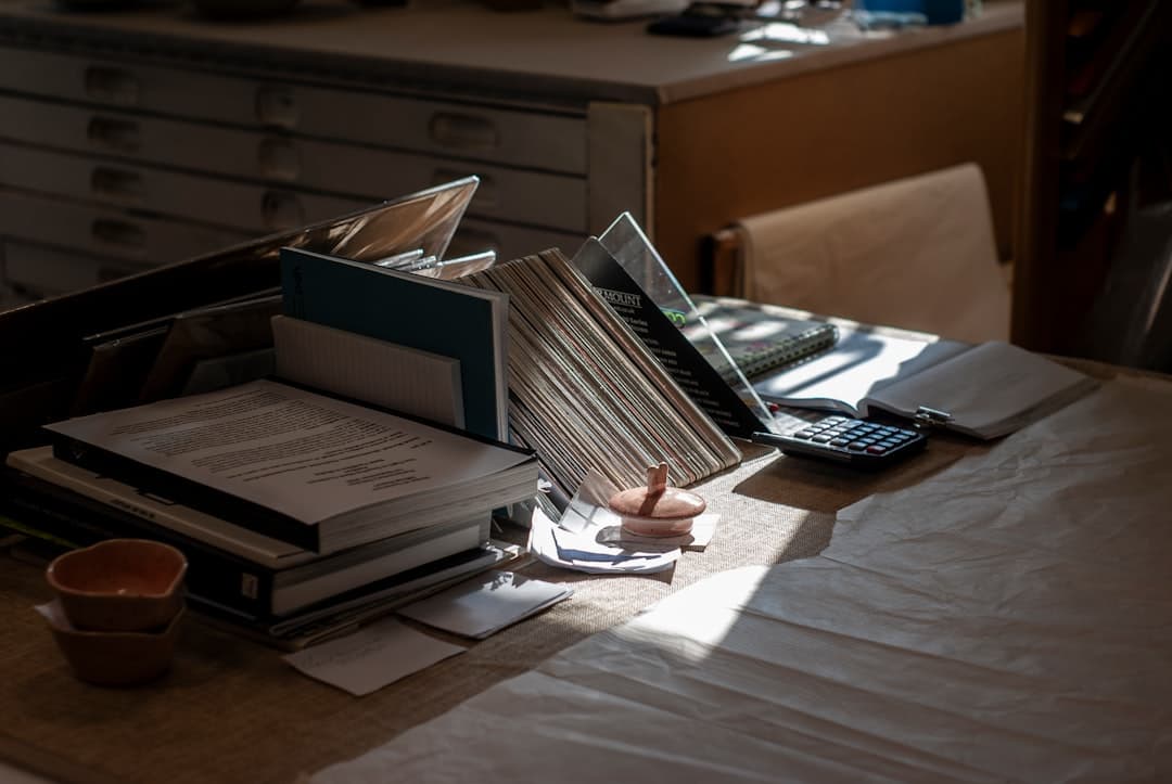 Small business owner organizing tax documents and paperwork at organized desk with filing system