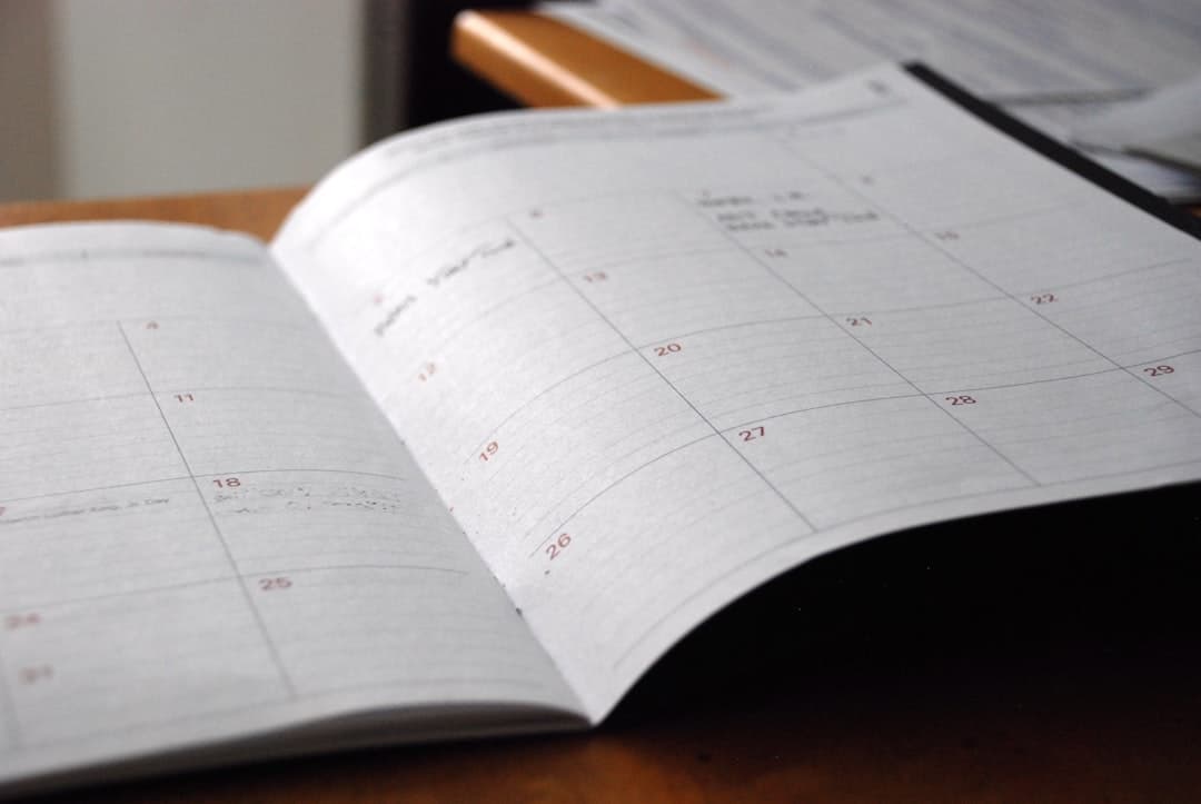 Business calendar with quarterly review dates marked, alongside organized tax documents and a laptop