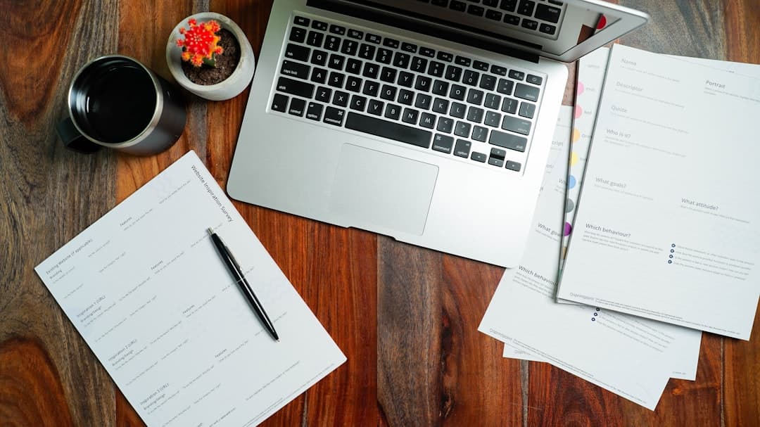 Small business owner reviewing contractor tax forms at a desk with a coffee mug and organized folders