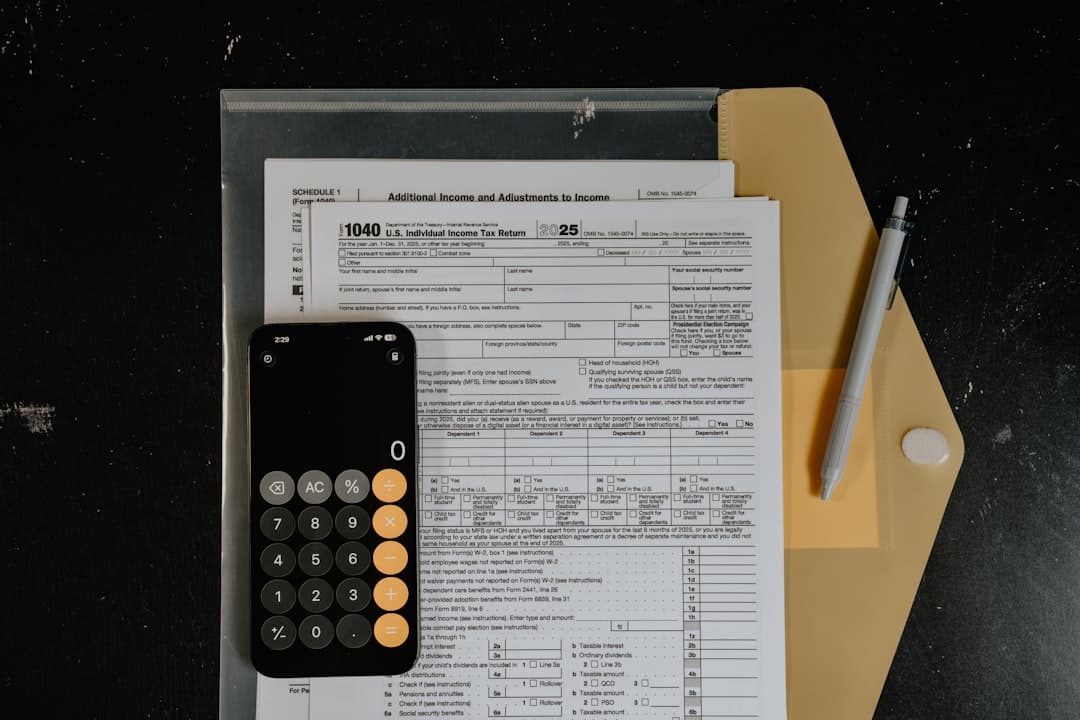 Business owner reviewing tax documents and calculator on desk