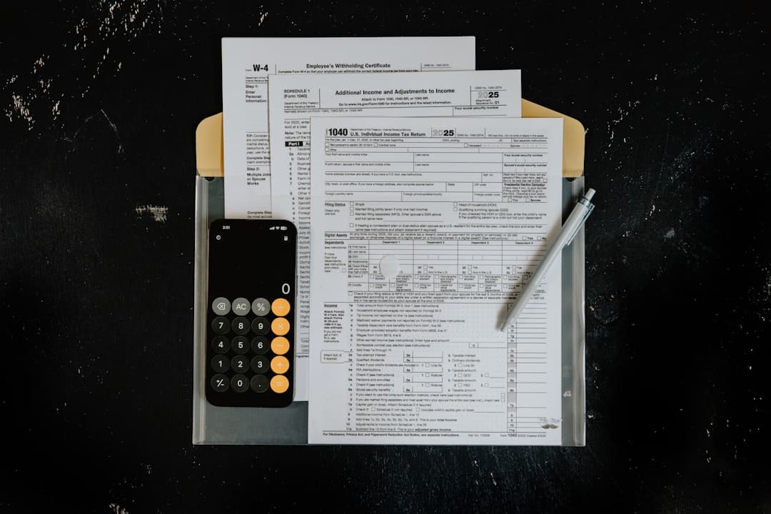Small business owner reviewing tax documents at desk with calculator and paperwork