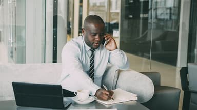 Small business owner reviewing tax documents and paperwork at desk with calculator and calendar